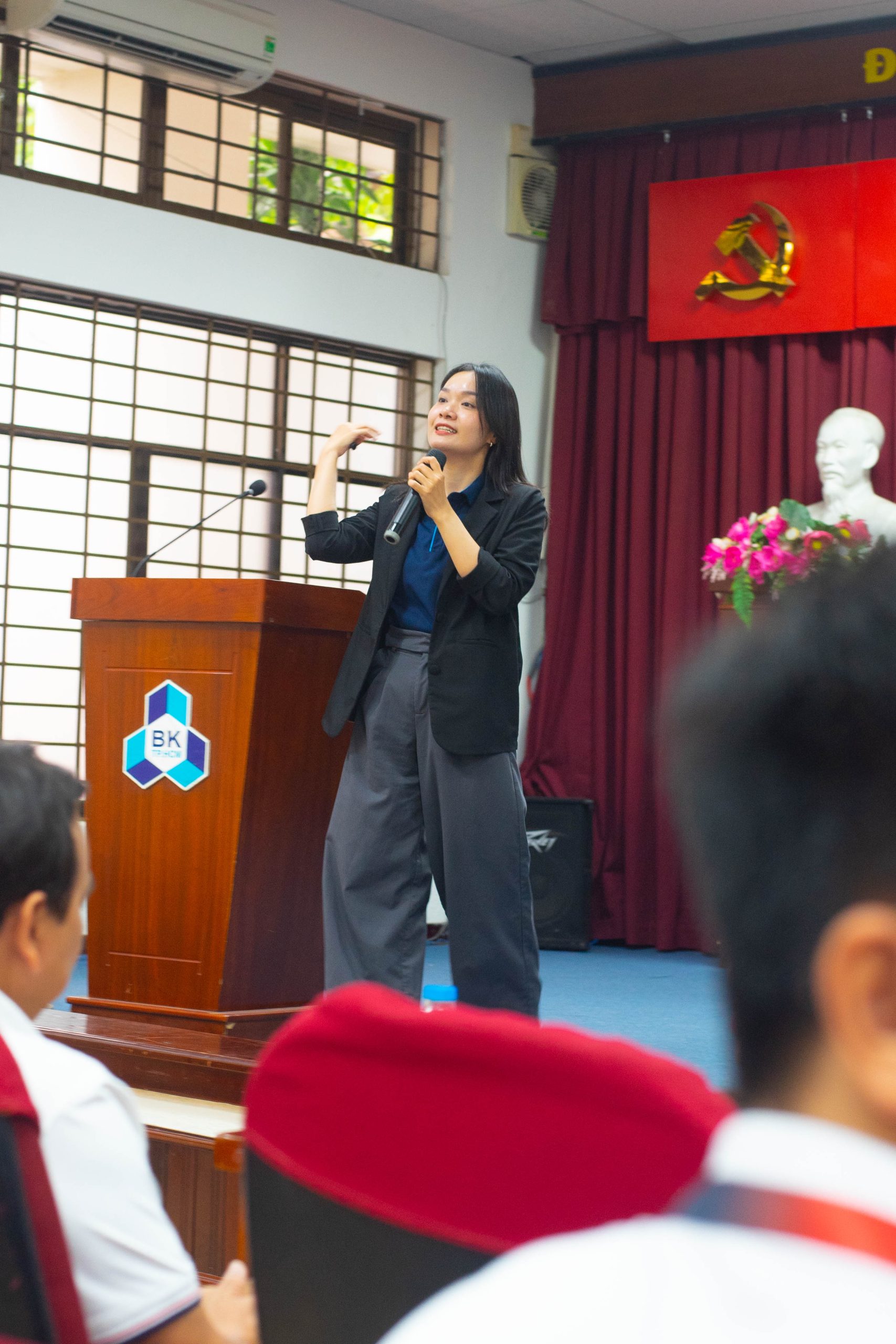 A person standing on a podium with a microphone Description automatically generated