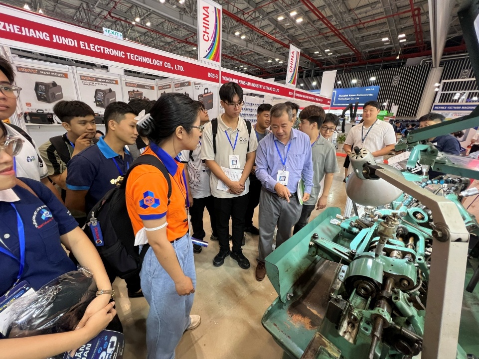 A group of people standing around a machine

AI-generated content may be incorrect.